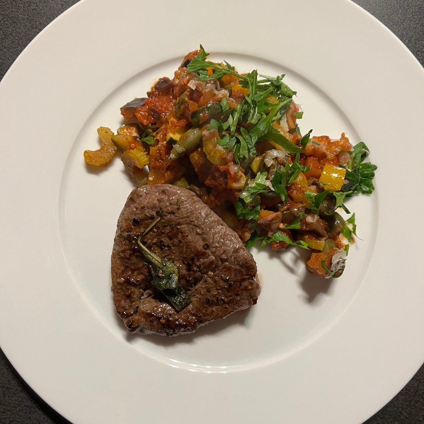 Ein Tablett mit köstlicher Caponata, einem traditionellen italienischen Gericht. Die Caponata besteht aus einer Mischung aus gebratenem Gemüse, Tomaten und Kräutern. Ein einfaches und schnelles Rezept für einen leckeren und gesunden Genuss!